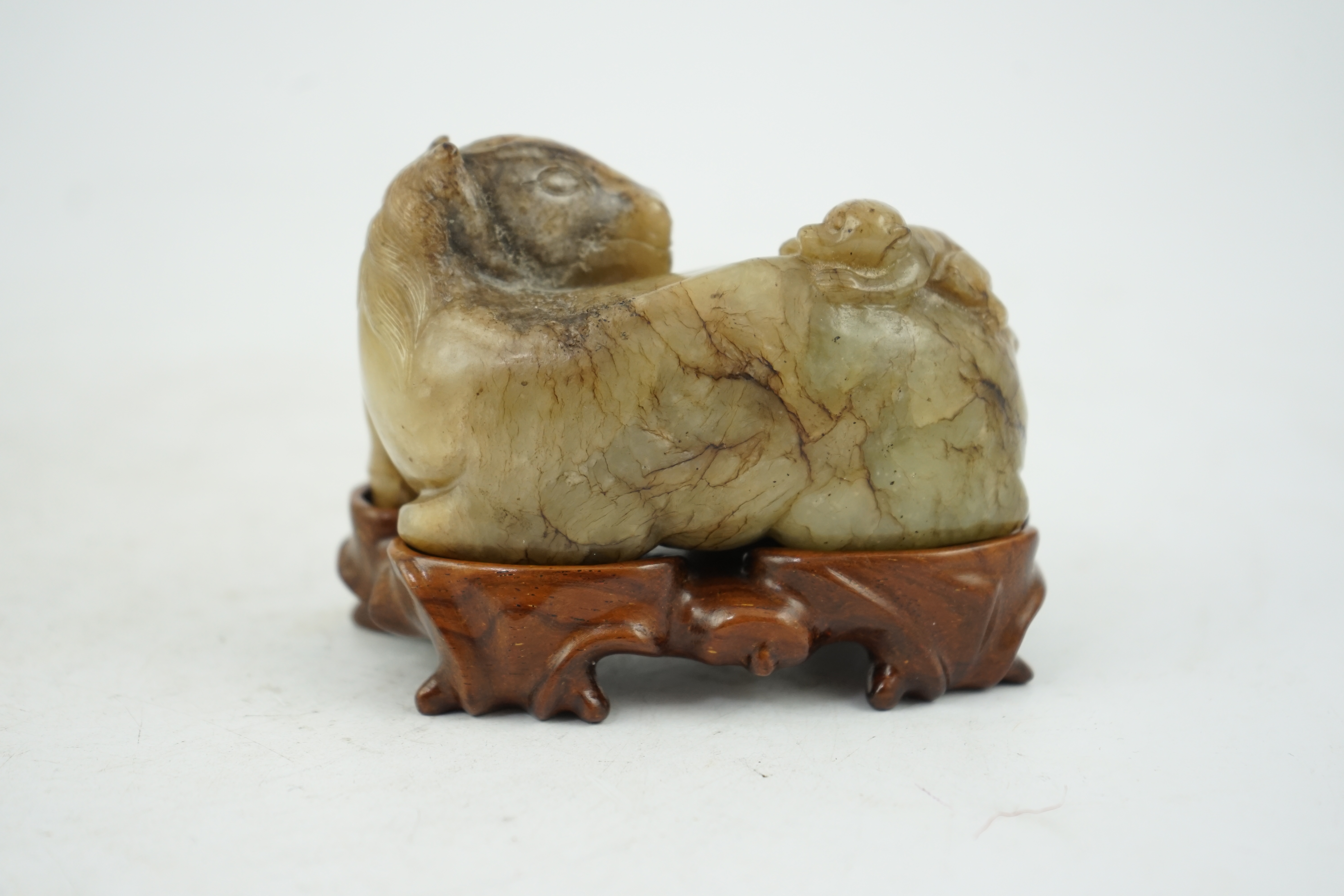 A Chinese celadon and mottled brown jade figure of a monkey climbing on a recumbent horse, Ming dynasty, 16th-17th century